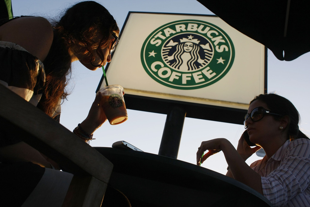 MIAMI - JANUARY 28: Customers relax and drink their beverages at a Starbucks Coffee shop on January 28, 2009 in Miami, Florida. Starbucks will lay off about 700 non-store workers by mid-February, including about 350 at its Seattle headquarters, as part of a reduction of 6,000 positions worldwide over the next eight months. The company also will close about 300 underperforming stores, according to a memo from CEO Howard Schultz. (Photo by Joe Raedle/Getty Images)